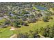 Beautiful aerial view of a community with a lush golf course, lovely pond, and many mature trees at 13009 Wedgewood Way # 63-D, Hudson, FL 34667