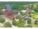 Aerial view of tennis courts and a community pool surrounded by lush trees at 13009 Wedgewood Way # 63-D, Hudson, FL 34667