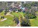 Stunning aerial view of the clubhouse featuring a sparkling pool, tennis courts, and lush green golf course at 13009 Wedgewood Way # 63-D, Hudson, FL 34667