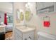 Compact bathroom with a vanity, storage cabinet, and a view into the adjacent bedroom with a window at 13009 Wedgewood Way # 63-D, Hudson, FL 34667