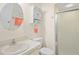 Well-lit bathroom featuring a round mirror, neutral tones, and a glass-enclosed shower for a clean and functional design at 13009 Wedgewood Way # 63-D, Hudson, FL 34667