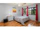 Cozy bedroom with hardwood floors and windows draped with decorative red curtains at 13009 Wedgewood Way # 63-D, Hudson, FL 34667