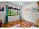 Bright bedroom with wood floors, a large window with green curtains, and wall art creating a comfortable living space at 13009 Wedgewood Way # 63-D, Hudson, FL 34667