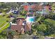 Breathtaking aerial view of the clubhouse, pool, and tennis courts in a lush, mature landscape at 13009 Wedgewood Way # 63-D, Hudson, FL 34667
