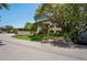 Exterior view of the home featuring lush landscaping, assigned covered parking, and a tidy lawn at 13009 Wedgewood Way # 63-D, Hudson, FL 34667