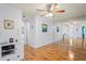 Open-concept living room with hardwood floors, mirror wall, and ceiling fan at 13009 Wedgewood Way # 63-D, Hudson, FL 34667