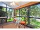 Sunroom featuring large windows, a ceiling fan, a small dining set, and carpeted floors providing a cozy space to relax at 13009 Wedgewood Way # 63-D, Hudson, FL 34667