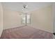 Neutral bedroom with plush carpet, a ceiling fan, and natural light from a large window at 13491 Coronado Dr, Spring Hill, FL 34609