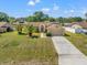 Charming single-story home featuring a well-maintained lawn, mature trees, and a spacious driveway leading to a two-car garage at 13491 Coronado Dr, Spring Hill, FL 34609