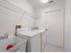 Well-lit laundry room with sink, washer, dryer, and shelving for organized convenience at 13491 Coronado Dr, Spring Hill, FL 34609