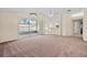 Inviting room with neutral carpet, ceiling fan, and sliding glass doors that lead to the outside at 13491 Coronado Dr, Spring Hill, FL 34609