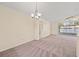 Open-concept living room showcasing a contemporary chandelier, and abundant natural light from the sliding glass doors at 13491 Coronado Dr, Spring Hill, FL 34609