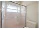 Shower featuring frosted glass doors and a toilet, offering privacy and convenience at 13491 Coronado Dr, Spring Hill, FL 34609