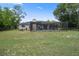 Large backyard featuring a screened pool enclosure and mature trees at 1376 Fayetteville Dr, Spring Hill, FL 34609