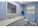 Bathroom features blue walls, a granite vanity top and tiled floor at 1376 Fayetteville Dr, Spring Hill, FL 34609