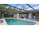 Beautiful screened-in pool area features a pristine pool with blue lounge chairs at 1376 Fayetteville Dr, Spring Hill, FL 34609