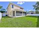Beautiful two-story home featuring a spacious backyard with a screened patio and a white fence at 13772 Dunwoody Dr, Spring Hill, FL 34609