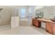 Bathroom featuring a soaking tub, double sink vanity, and glass enclosed shower at 13772 Dunwoody Dr, Spring Hill, FL 34609