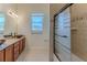 Stylish bathroom featuring dual vanity with granite countertop and glass-enclosed tub/shower at 13772 Dunwoody Dr, Spring Hill, FL 34609