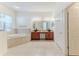 Bathroom featuring a soaking tub, double sink vanity, and tile flooring at 13772 Dunwoody Dr, Spring Hill, FL 34609