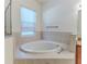 Close up on the bathroom soaking tub with tile surround and chrome hardware at 13772 Dunwoody Dr, Spring Hill, FL 34609