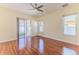 Primary bedroom features wood floors, a ceiling fan, and sliding glass doors to the patio at 13772 Dunwoody Dr, Spring Hill, FL 34609