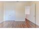 Spacious bedroom with double doors and wood flooring, leading to an open doorway at 13772 Dunwoody Dr, Spring Hill, FL 34609
