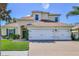 Two story home showcasing a well maintained yard, green door, 2-car garage, and neutral color palette at 13772 Dunwoody Dr, Spring Hill, FL 34609