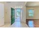 Foyer with tiled floors, hardwood floors, an open front door, a white walls at 13772 Dunwoody Dr, Spring Hill, FL 34609