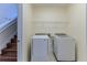 Laundry room with washer and dryer, showcasing convenient shelving and access to stairs at 13772 Dunwoody Dr, Spring Hill, FL 34609