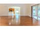 Open-concept living room features wood floors, view of the kitchen, and sliding glass doors to the patio at 13772 Dunwoody Dr, Spring Hill, FL 34609