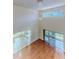 A view of the light-filled living room, with hardwood floors, a tall ceiling and large windows at 13772 Dunwoody Dr, Spring Hill, FL 34609