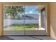 View from the screened patio overlooking the fenced backyard and lush greenery creates a private retreat at 13772 Dunwoody Dr, Spring Hill, FL 34609