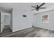 Spacious bedroom with wood-look floors, a modern fan, and a wall-mounted TV bracket at 13821 Judy Ave, Hudson, FL 34667