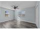Well-lit bedroom featuring modern ceiling fan, wood-look flooring, and sunny windows at 13821 Judy Ave, Hudson, FL 34667