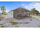 View of the screened-in porch, and a yard with well-placed white rock at 13821 Judy Ave, Hudson, FL 34667