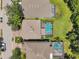 An aerial shot highlighting the backyard pools of neighboring homes, each encased in a screened enclosure at 1410 Halapa Way, Trinity, FL 34655