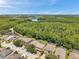 A serene lake is surrounded by lush greenery and well-spaced residences in this aerial shot at 1410 Halapa Way, Trinity, FL 34655
