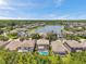 Picturesque aerial view of a community surrounding a beautiful lake, boasting homes with private pools at 1410 Halapa Way, Trinity, FL 34655