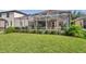 A lush lawn and landscaping surround the screened-in pool and patio area at 1410 Halapa Way, Trinity, FL 34655