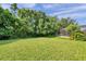 Large backyard with a well-maintained lawn and mature trees offering privacy at 1410 Halapa Way, Trinity, FL 34655
