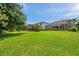 Large backyard with lush grass and screened patios offers ample space for recreation and relaxation at 1410 Halapa Way, Trinity, FL 34655