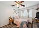 Comfortable bedroom with a ceiling fan, laminate wood flooring, and natural light at 1410 Halapa Way, Trinity, FL 34655