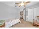 Bright bedroom featuring neutral paint, carpet, a ceiling fan, and closet space with a full-length mirror at 1410 Halapa Way, Trinity, FL 34655