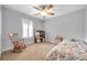 Cozy bedroom features neutral walls, carpet floors, a ceiling fan, and a sunny window with shutter blinds at 1410 Halapa Way, Trinity, FL 34655