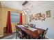 Elegant dining area with a large wooden table, stylish pendant lighting, and bright red curtains at 1410 Halapa Way, Trinity, FL 34655