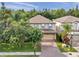 Charming two-story home with a brick driveway and well-manicured front yard at 1410 Halapa Way, Trinity, FL 34655