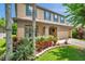 Charming home features manicured landscaping, neutral paint, blue shutters and a two-car garage at 1410 Halapa Way, Trinity, FL 34655