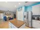 Open concept kitchen with stainless refrigerator and an island that seamlessly connect to the living area at 1410 Halapa Way, Trinity, FL 34655