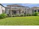 Beautiful screened-in pool area with lush green lawn and landscaped hedges at 1410 Halapa Way, Trinity, FL 34655